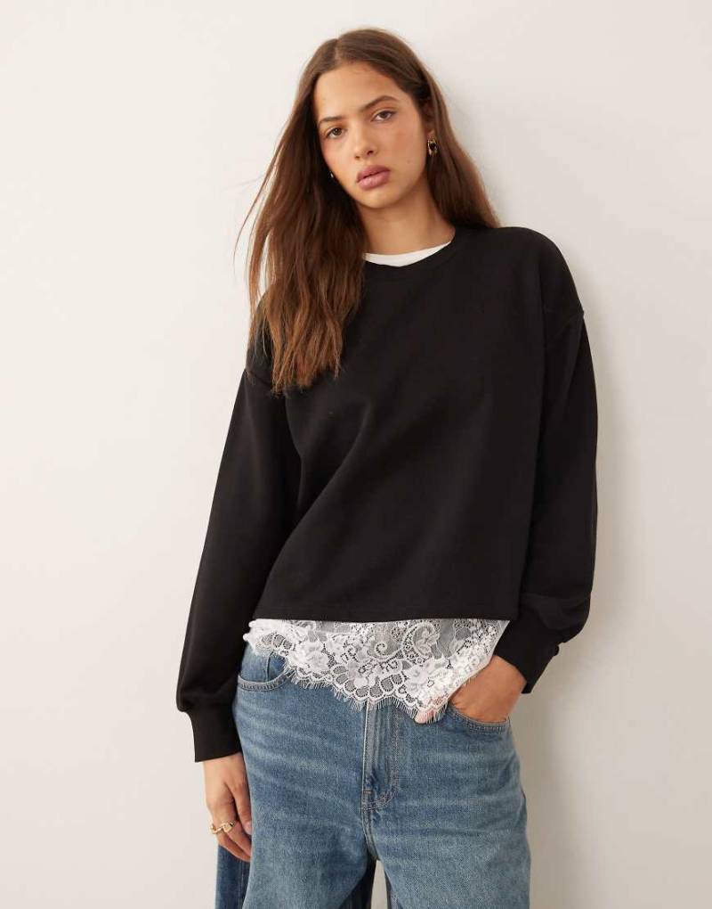 ASOS DESIGN - Oversize-Sweatshirt in Schwarz mit Spitzenunterlage am Saum von ASOS DESIGN