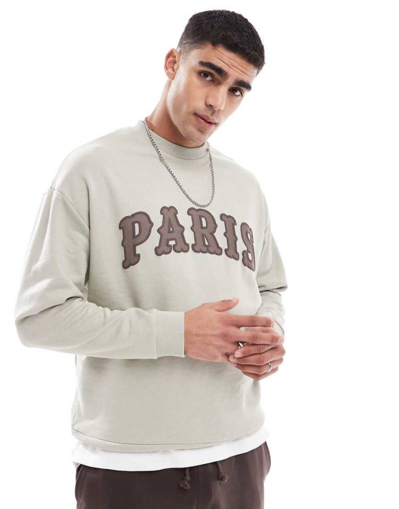 ASOS DESIGN - Oversize-Sweatshirt in gebrochenem Weiß mit Applikation auf der Brust von ASOS DESIGN
