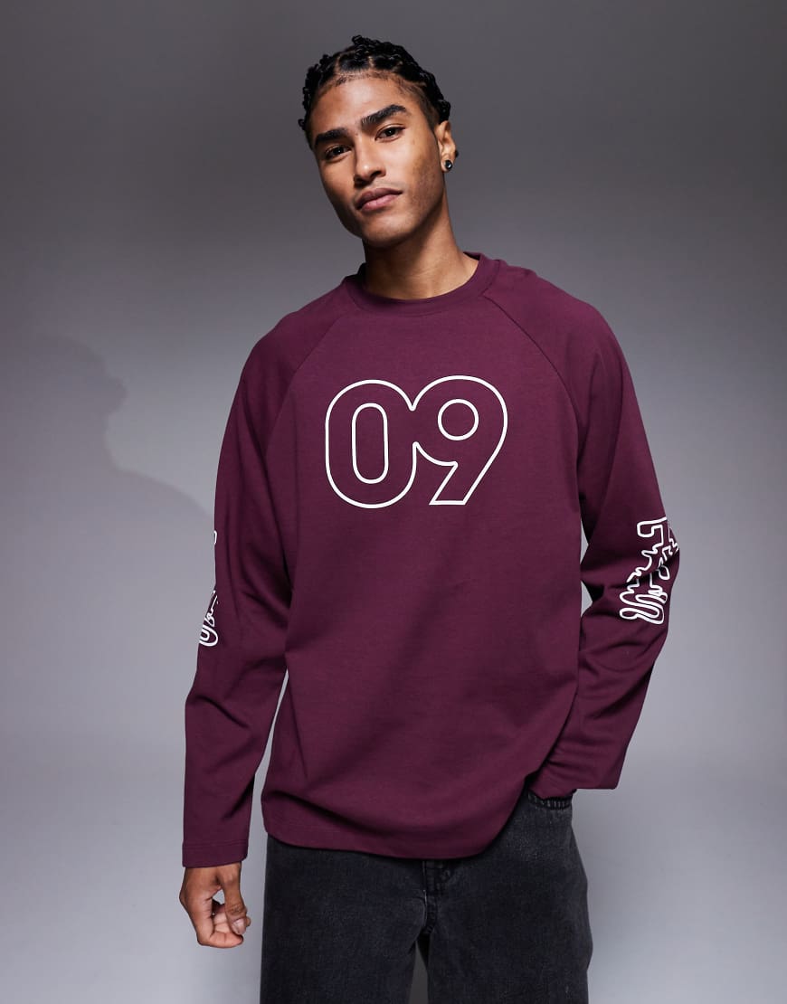 ASOS DESIGN - Oversize-T-Shirt in Burgunderrot mit langen Raglanärmeln und sportivem Grafikprint mit Flockdruck von ASOS DESIGN
