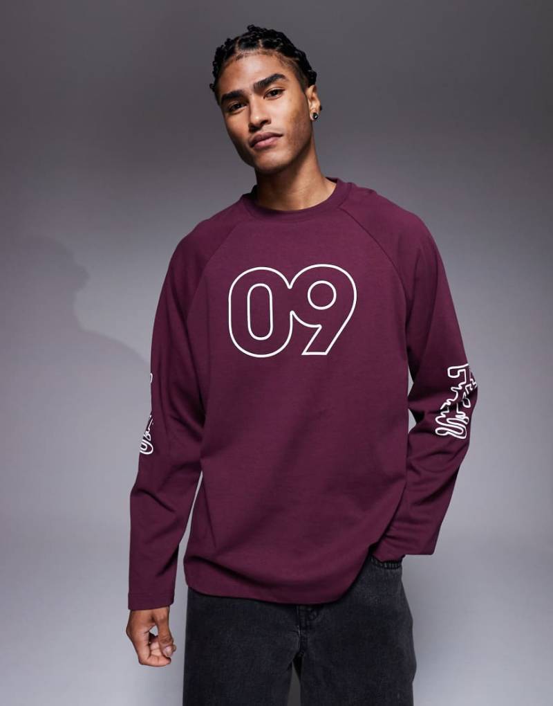 ASOS DESIGN - Oversize-T-Shirt in Burgunderrot mit langen Raglanärmeln und sportivem Grafikprint mit Flockdruck von ASOS DESIGN