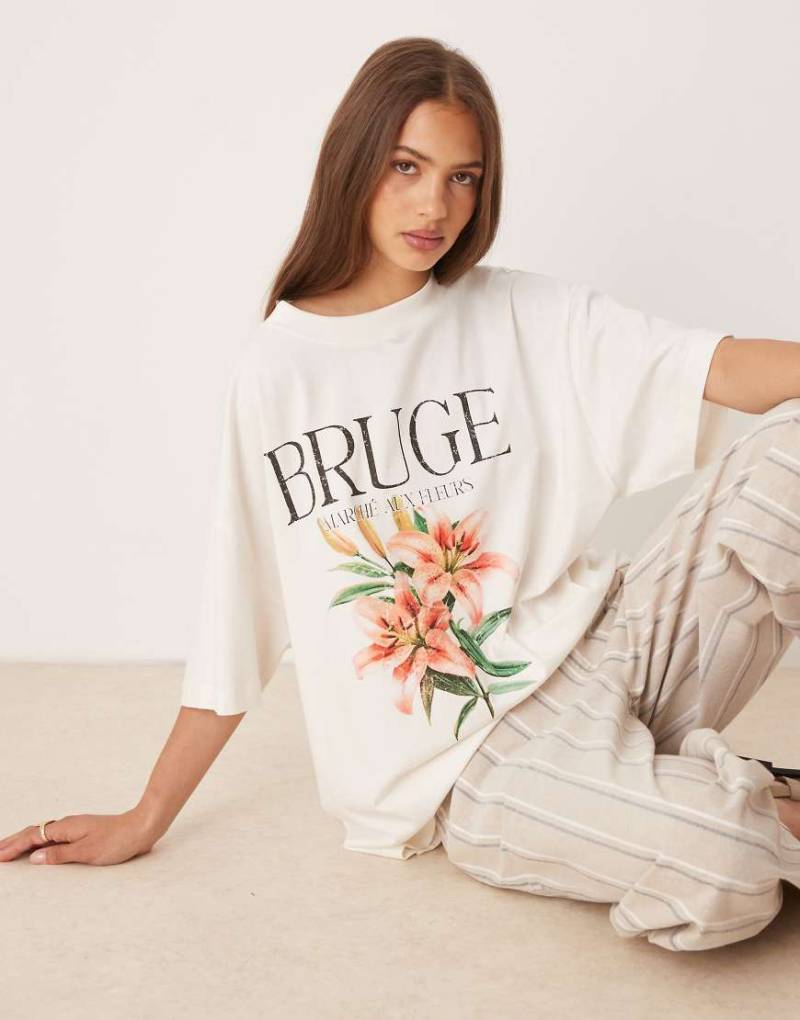 ASOS DESIGN - Oversize-T-Shirt in Cremeweiß mit „Bruge"-Slogan und Blumenprint von ASOS DESIGN