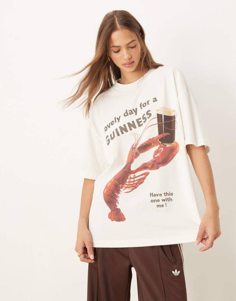 ASOS DESIGN - Oversize-T-Shirt in Cremeweiß mit „Guinness"-Schriftzug und Hummer-Grafikprint von ASOS DESIGN