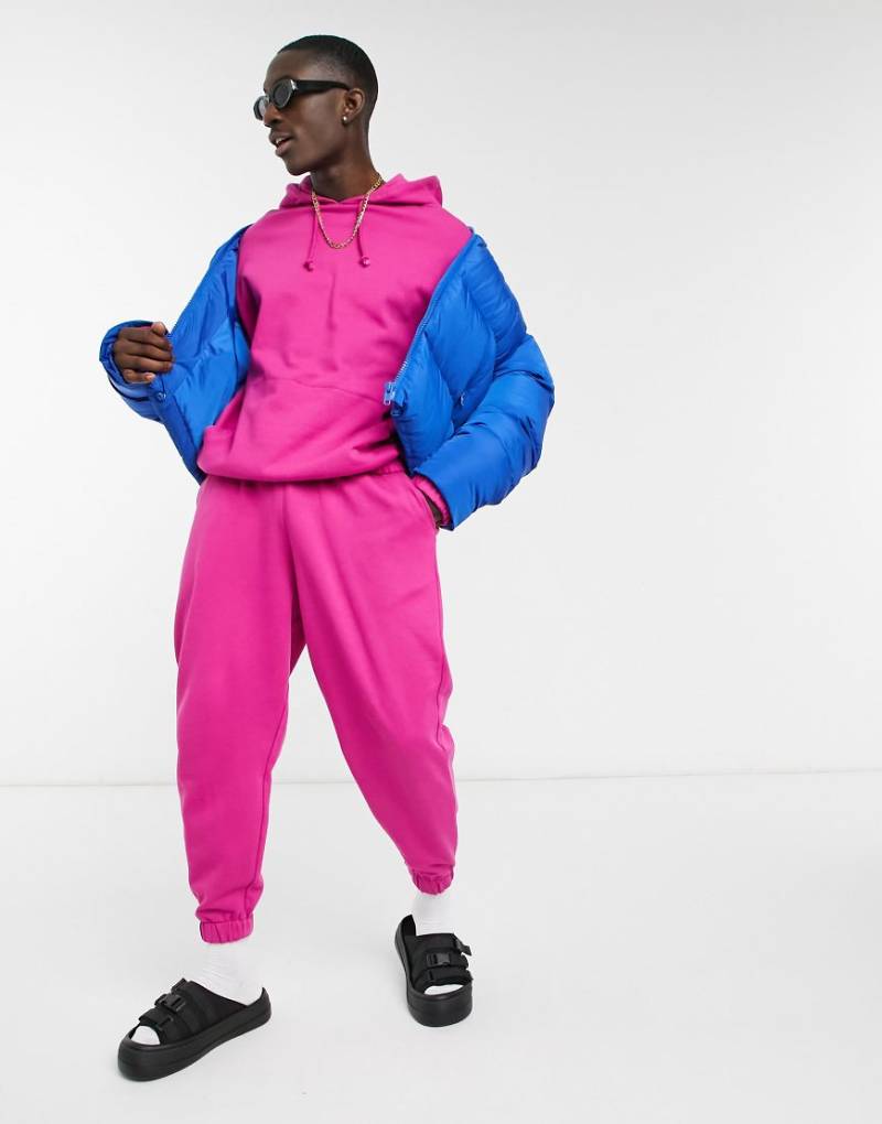 ASOS DESIGN - Oversize-Trainingsanzug, bestehend aus Kapuzenpullover und Jogginghose in leuchtendem Rosa von ASOS DESIGN
