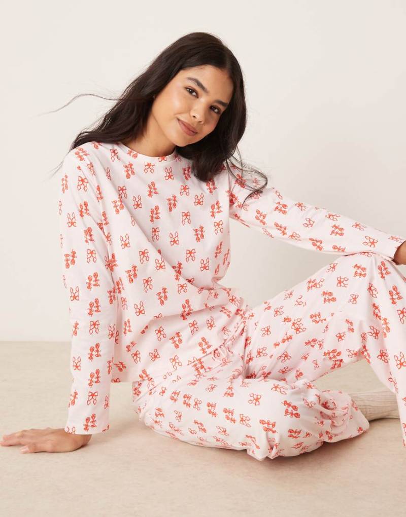 ASOS DESIGN - Pyjama mit langärmligem Oberteil und Hose in Rosa mit Schleifen-Print in Rot von ASOS DESIGN