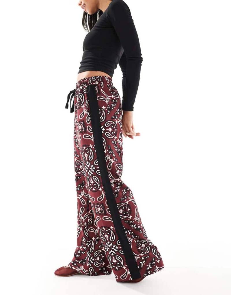 ASOS DESIGN - Schlupfhose in dunklem Kirschrot mit Kontrastbahn und Bandana-Muster von ASOS DESIGN
