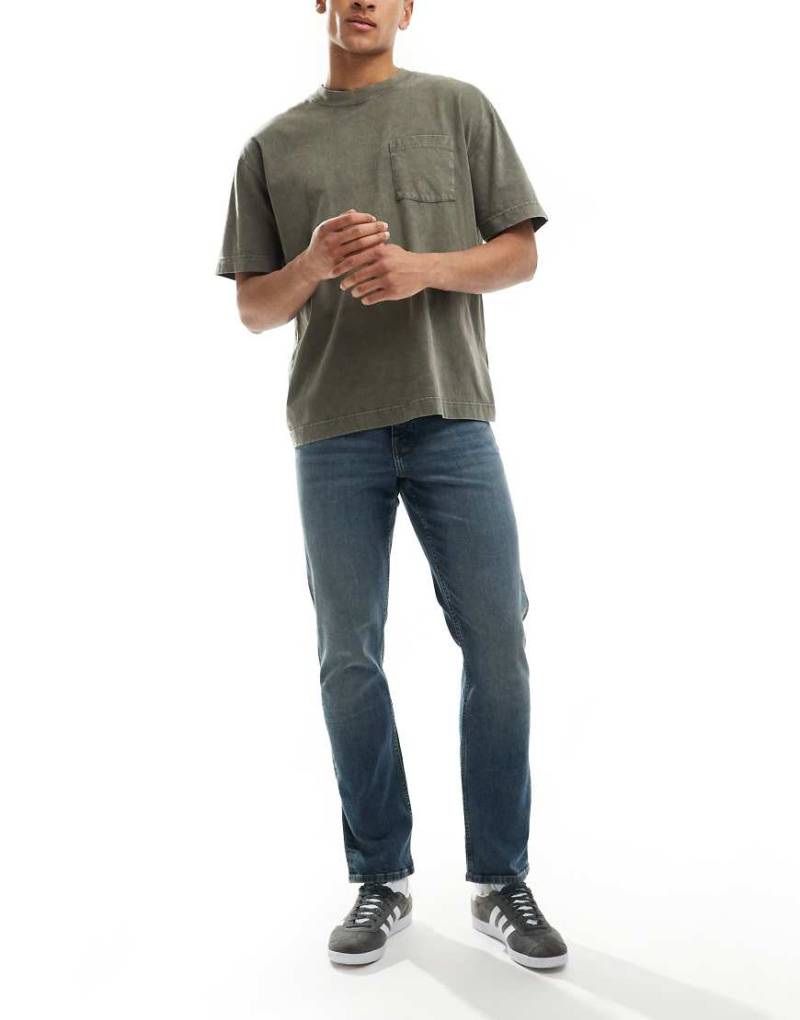 ASOS DESIGN - Schmal geschnittene Jeans in verwaschenem Mittelblau von ASOS DESIGN