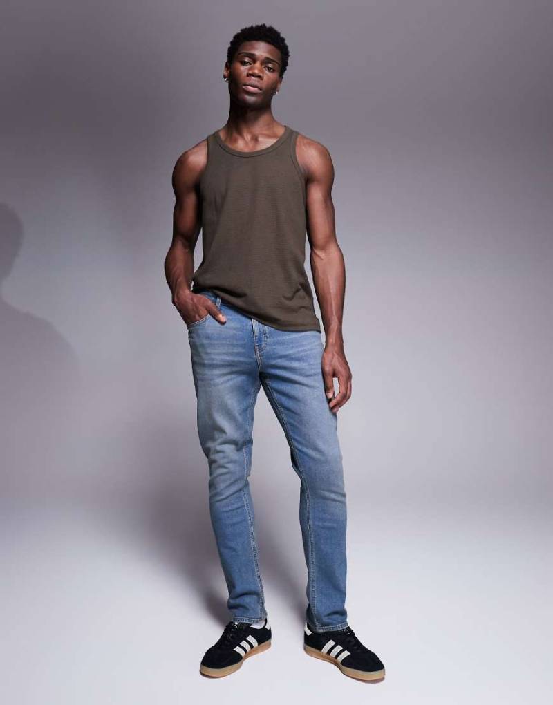 ASOS DESIGN - Schmal geschnittene Jeans in verwaschener, dunkelblauer Tönung von ASOS DESIGN