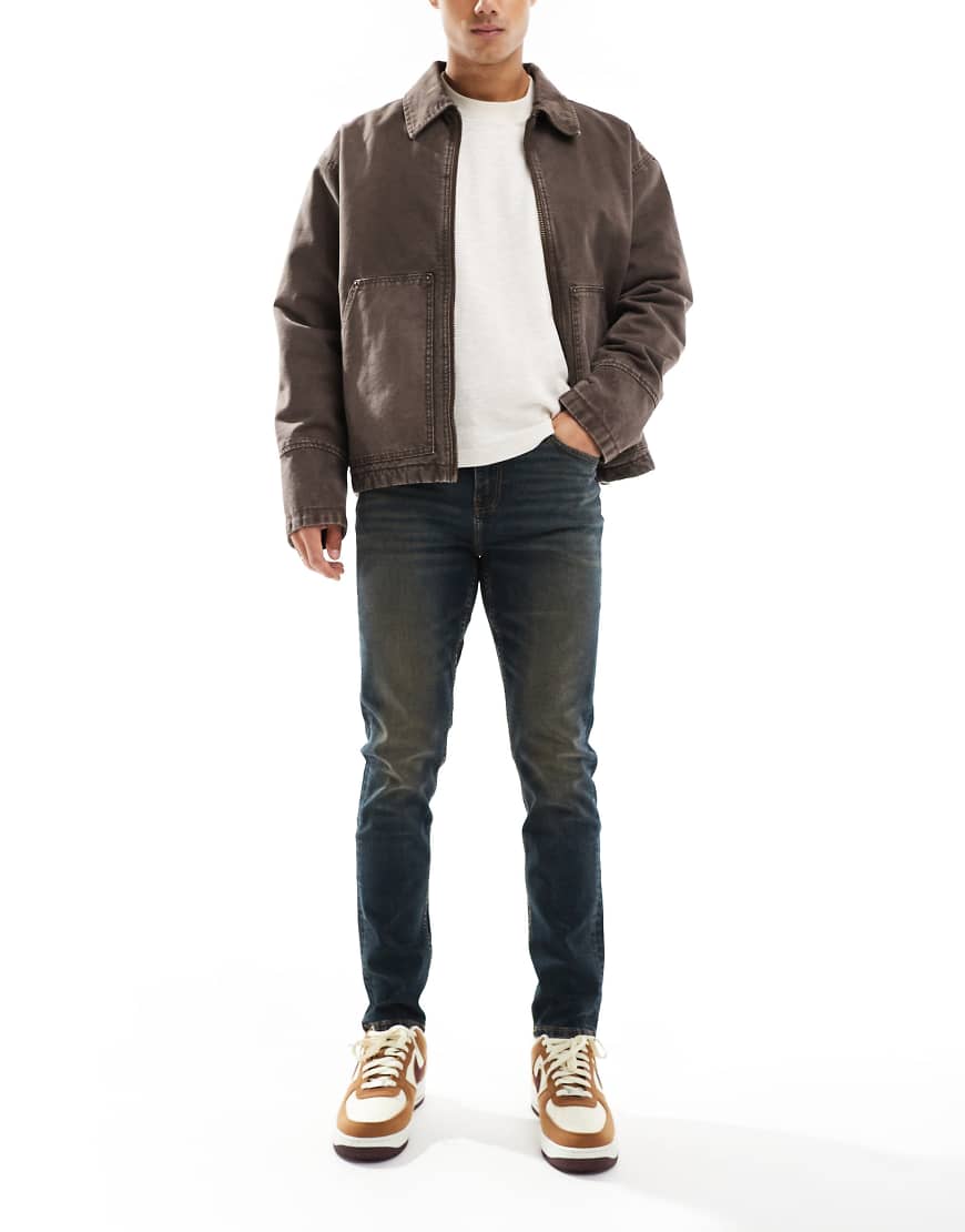 ASOS DESIGN - Schmal geschnittene Jeans in verwaschener dunkelblauer Tönung von ASOS DESIGN