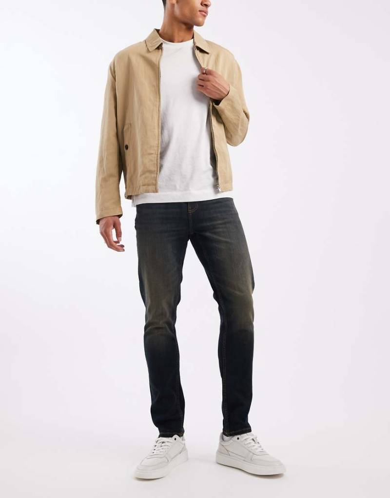 ASOS DESIGN - Schmal geschnittene Jeans in verwaschener dunkelblauer Tönung von ASOS DESIGN