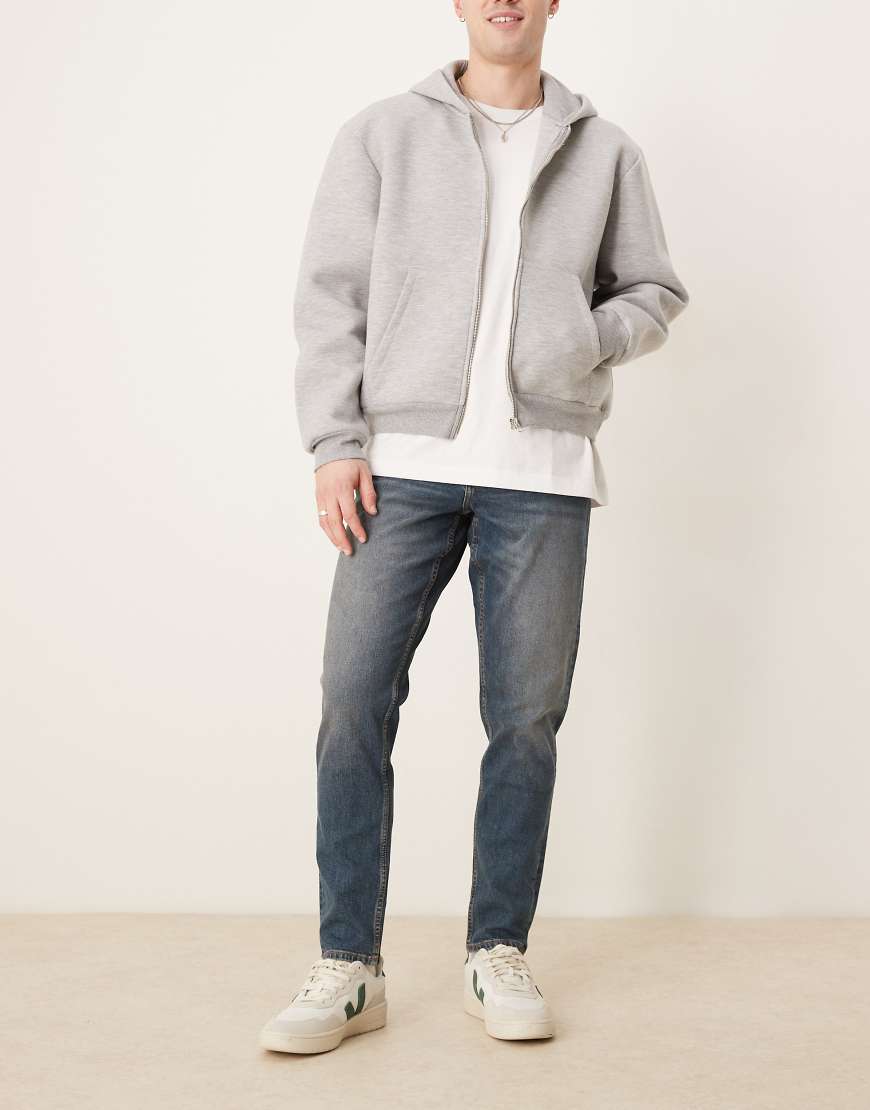 ASOS DESIGN - Schmal zulaufende, elastische Jeans in mittelblauer Waschung von ASOS DESIGN