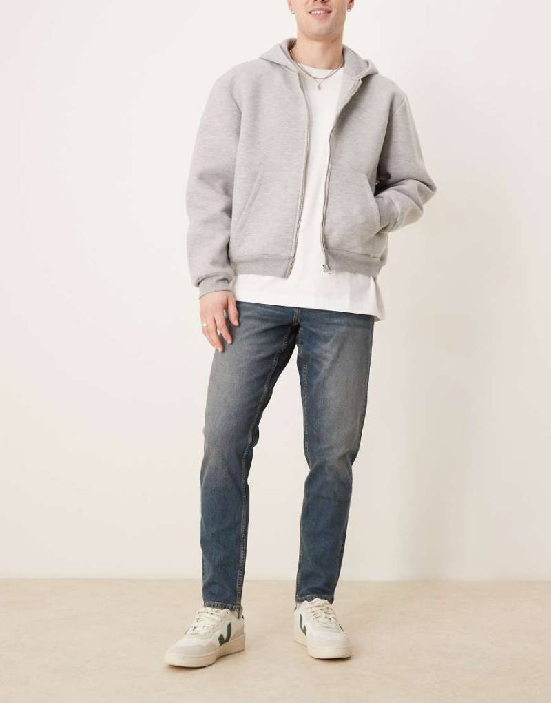 ASOS DESIGN - Schmal zulaufende, elastische Jeans in mittelblauer Waschung von ASOS DESIGN