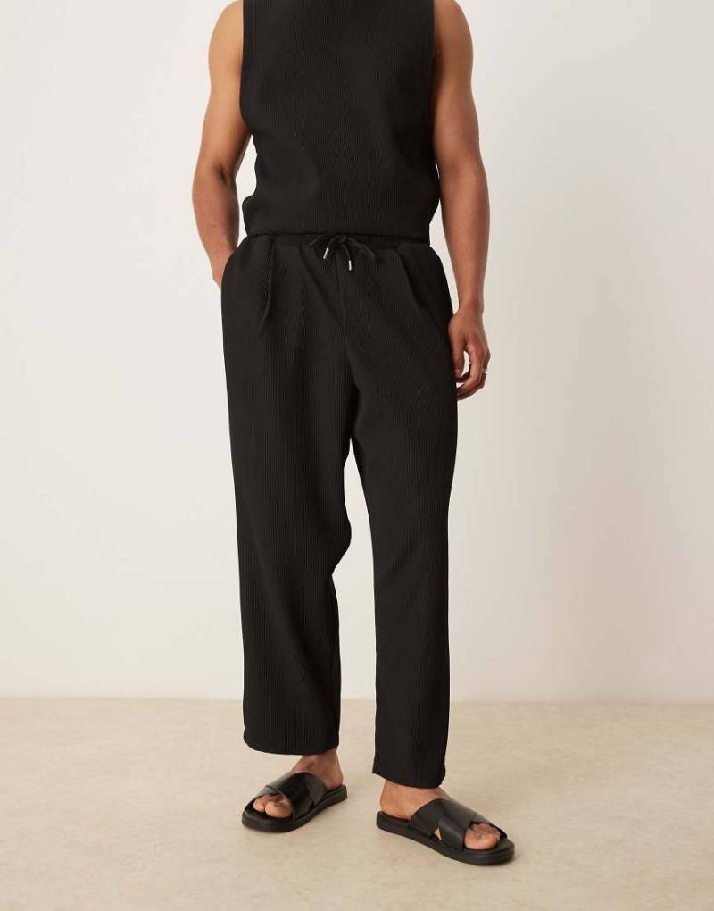 ASOS DESIGN - Schmal zulaufende, lässig geschnittene Jogginghose in plissiertem Schwarz von ASOS DESIGN