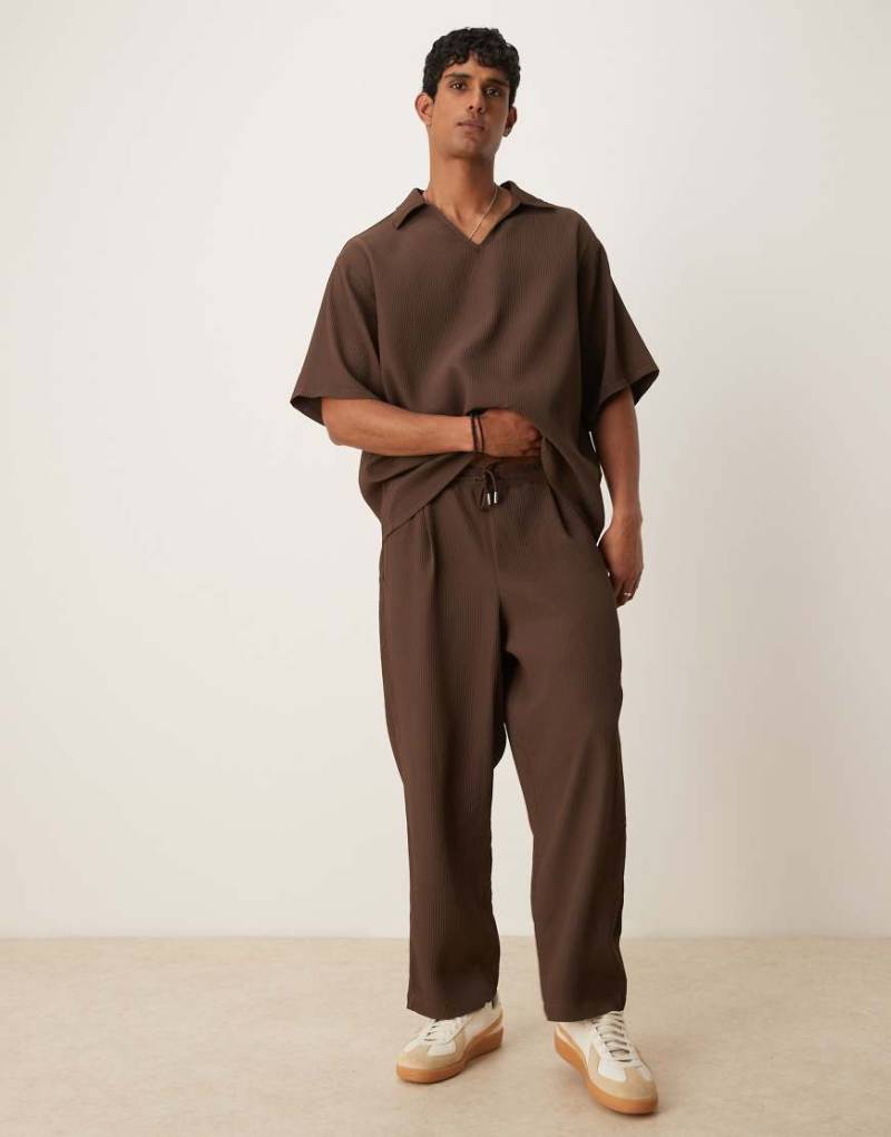 ASOS DESIGN - Schmal zulaufende, plissierte Jogginghose in Braun mit schmalem Schnitt von ASOS DESIGN
