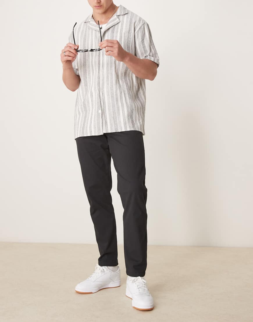 ASOS DESIGN - Schmal zulaufende Chinohose in Schwarz ASOS DESIGN - Schmal zulaufende Chinohose in Schwarz von ASOS DESIGN