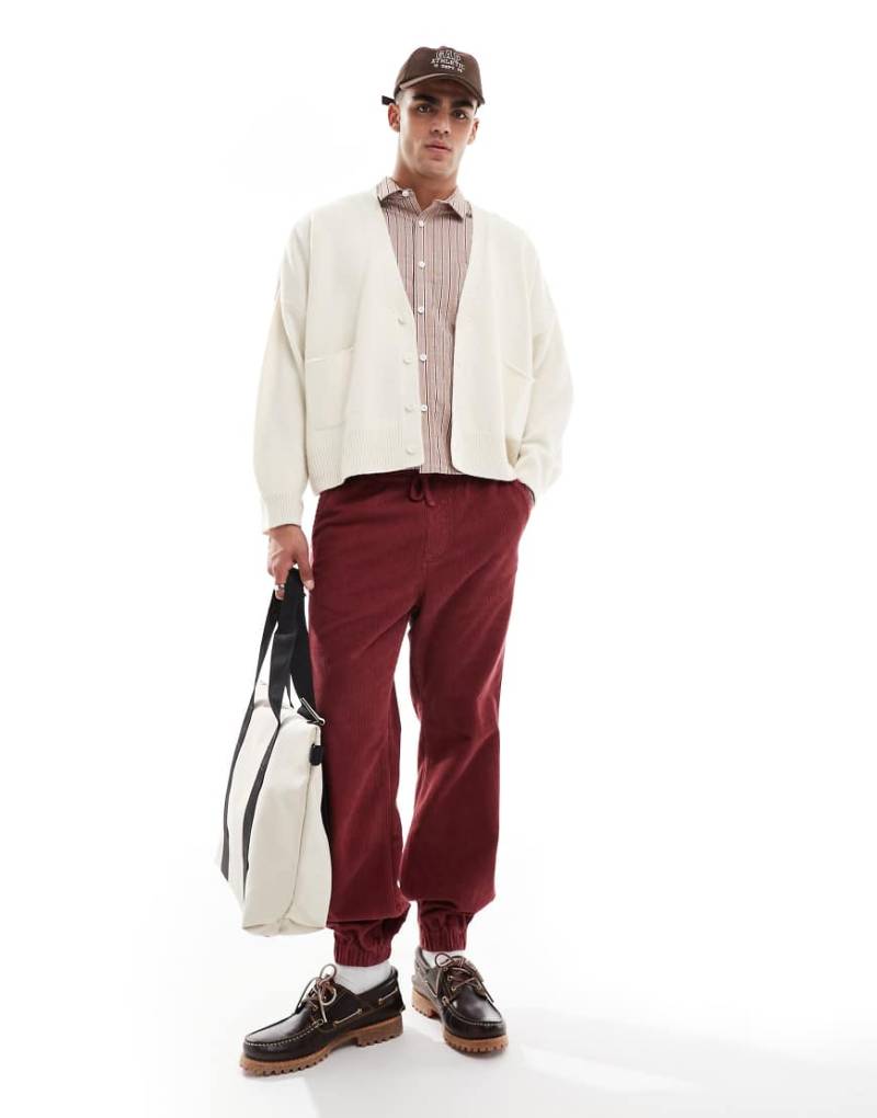 ASOS DESIGN - Schmal zulaufende Cord-Jogginghose in verwaschenem Burgunderrot von ASOS DESIGN