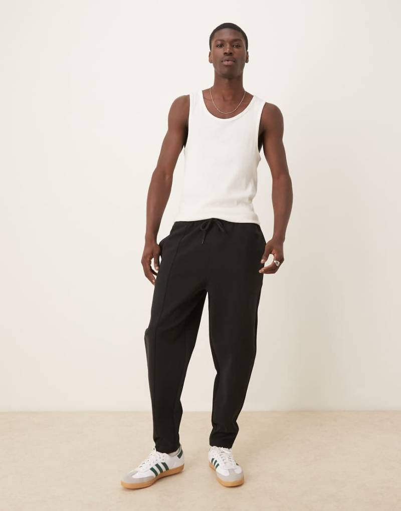 ASOS DESIGN - Schmal zulaufende Doubleface-Jogginghose in Schwarz mit Biesen von ASOS DESIGN