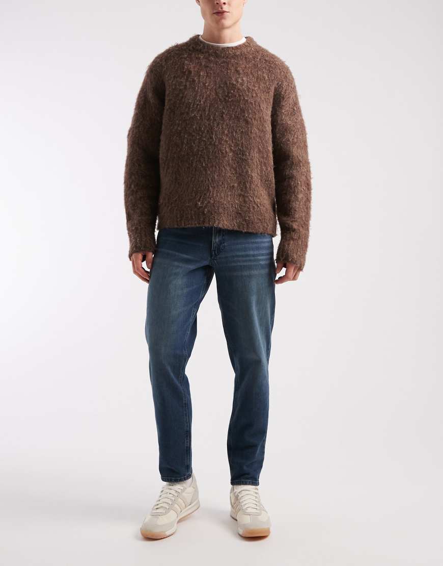 ASOS DESIGN - Schmal zulaufende Jeans in blauer Waschung von ASOS DESIGN