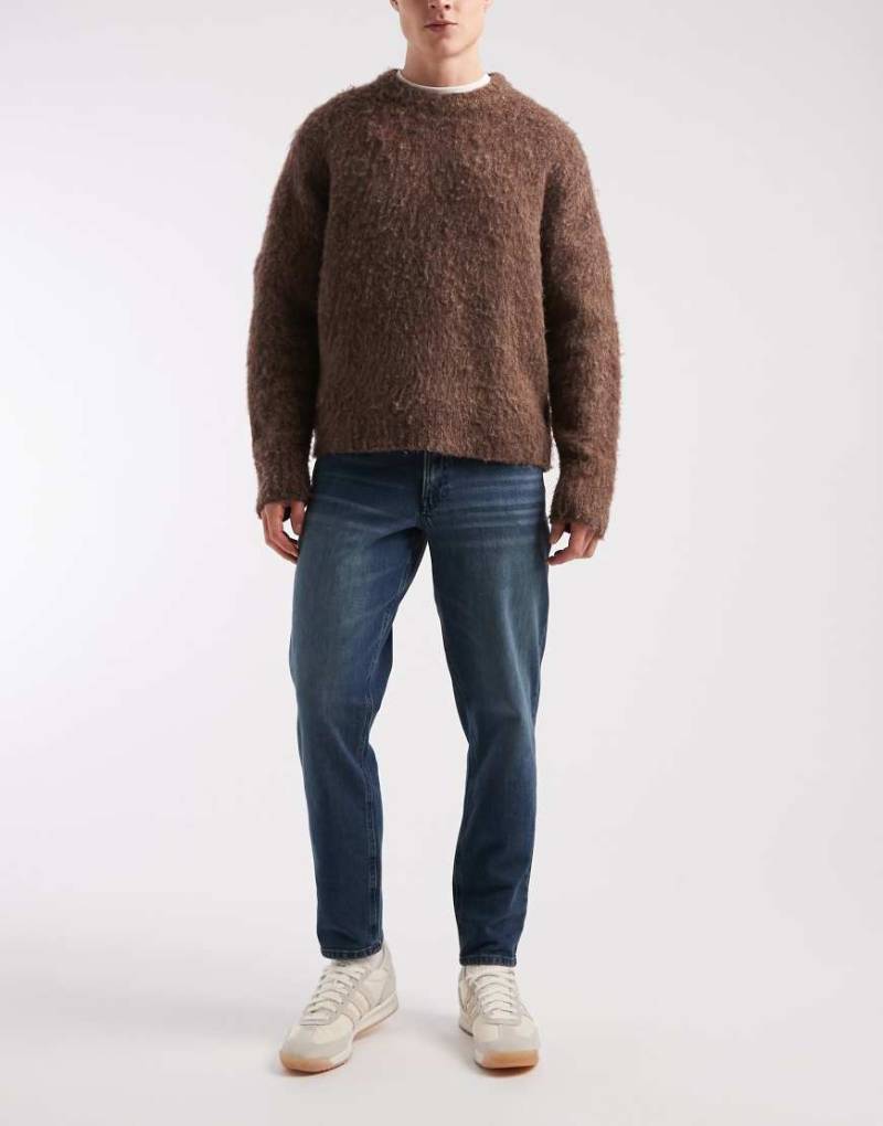 ASOS DESIGN - Schmal zulaufende Jeans in blauer Waschung von ASOS DESIGN