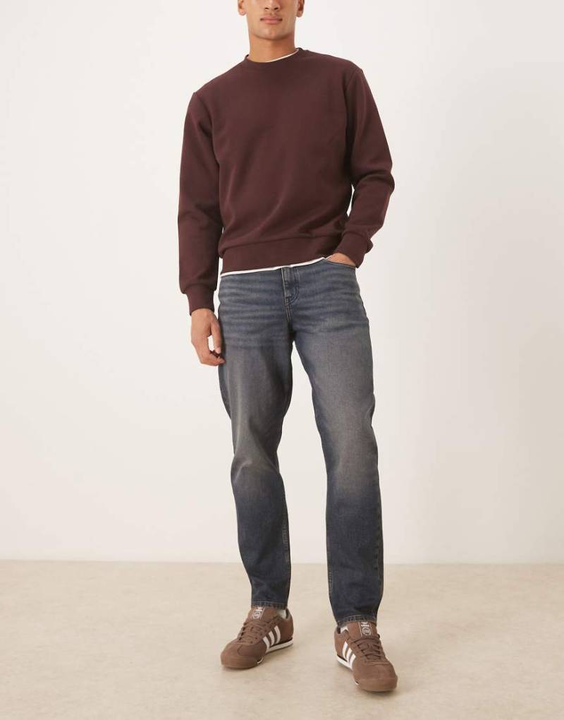 ASOS DESIGN - Schmal zulaufende Jeans in dunkelblauer Waschung mit Farbstich von ASOS DESIGN