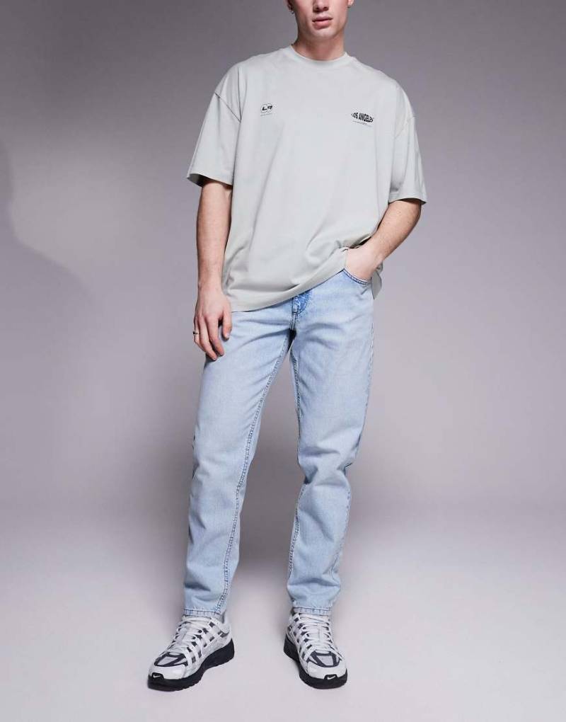 ASOS DESIGN - Schmal zulaufende Jeans in hellblauer Waschung von ASOS DESIGN