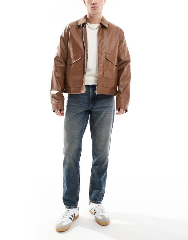ASOS DESIGN - Schmal zulaufende Jeans in mittelblauer Waschung mit Farbstich von ASOS DESIGN