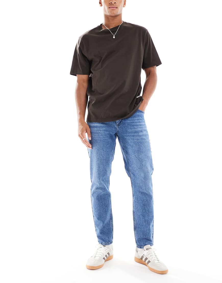 ASOS DESIGN - Schmal zulaufende Jeans in mittelblauer Waschung ASOS DESIGN - Schmal zulaufende Jeans in mittelblauer Waschung von ASOS DESIGN