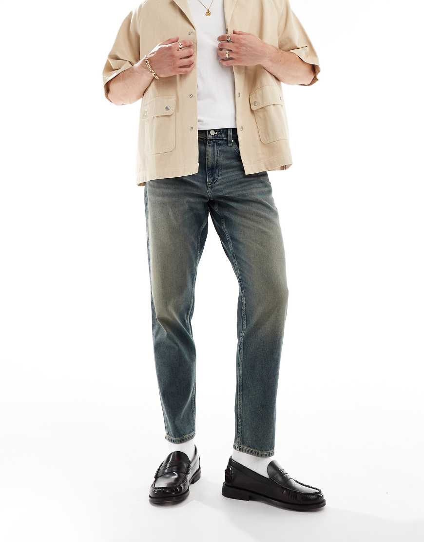 ASOS DESIGN - Schmal zulaufende Jeans in mittelblauer Waschung ASOS DESIGN - Schmal zulaufende Jeans in mittelblauer Waschung von ASOS DESIGN