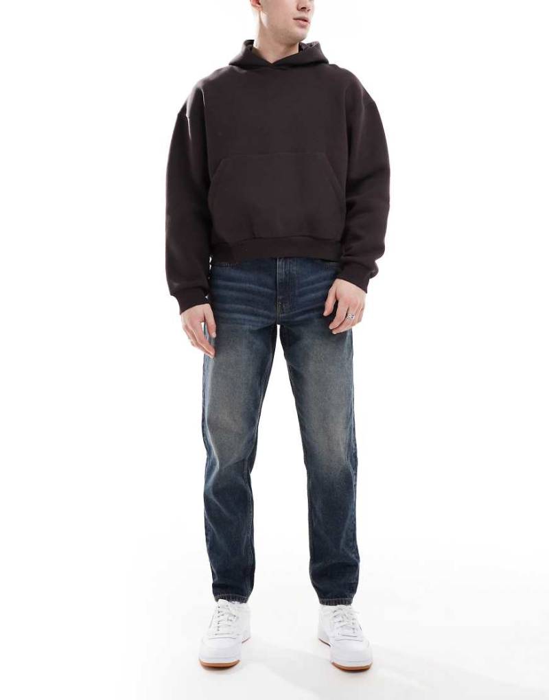 ASOS DESIGN - Schmal zulaufende Jeans in verwaschenem Dunkelblau mit Vintage-Tönung von ASOS DESIGN