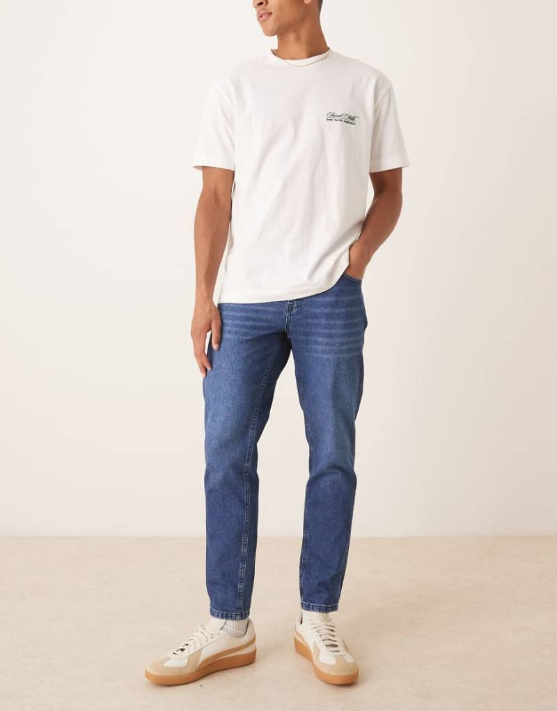 ASOS DESIGN - Schmal zulaufende Jeans in verwaschenem Dunkelblau von ASOS DESIGN