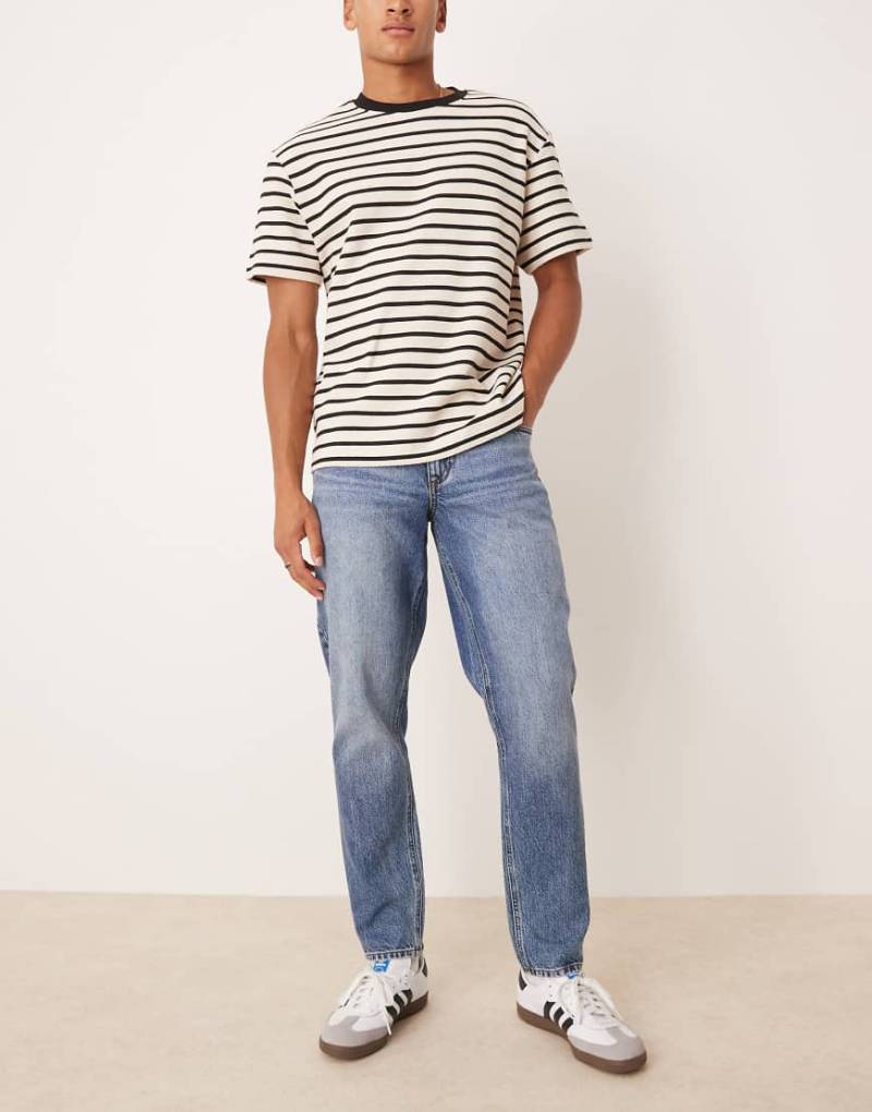 ASOS DESIGN - Schmal zulaufende Jeans in mittelblauer Waschung von ASOS DESIGN