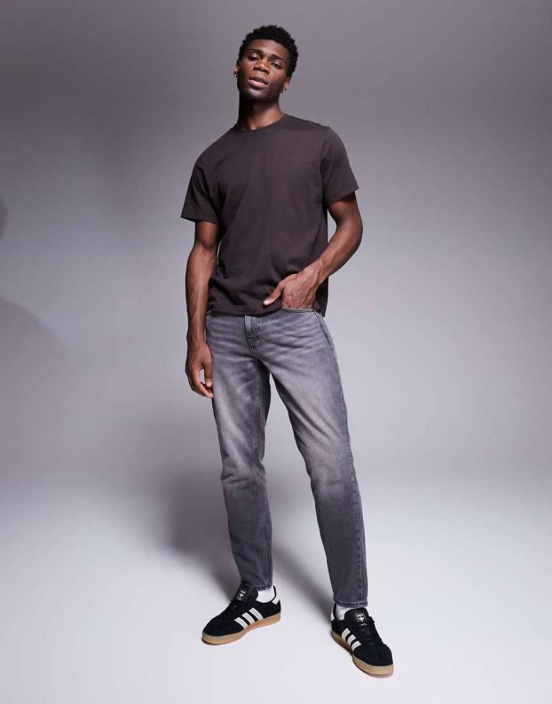 ASOS DESIGN - Schmal zulaufende Jeans in verwaschenem Grau-Schwarz von ASOS DESIGN