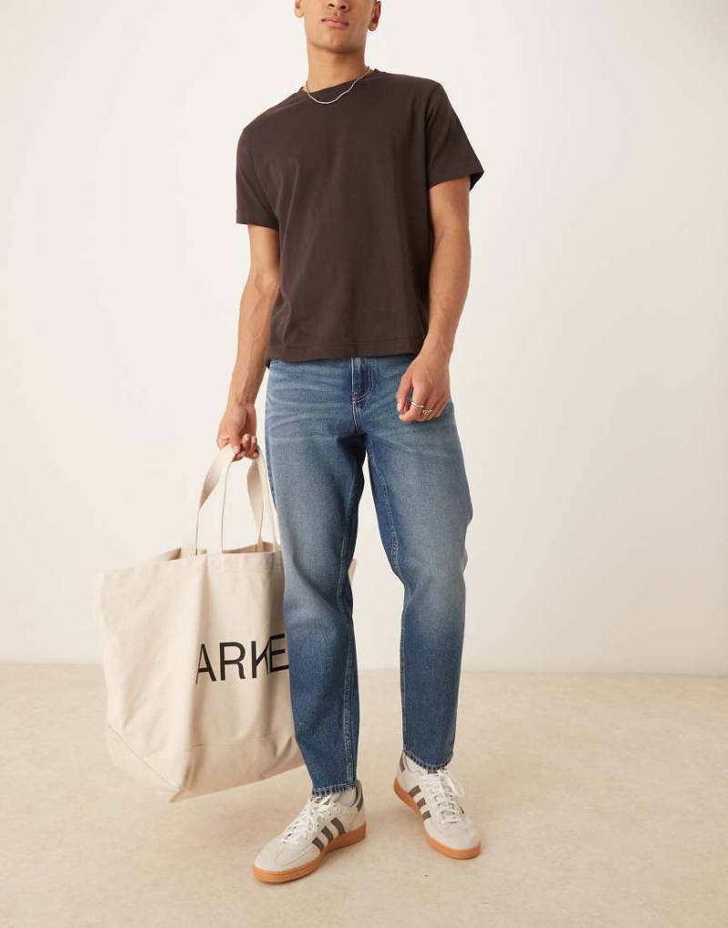ASOS DESIGN - Schmal zulaufende Jeans in verwaschenem Hellblau mit Vintage-Farbstich von ASOS DESIGN