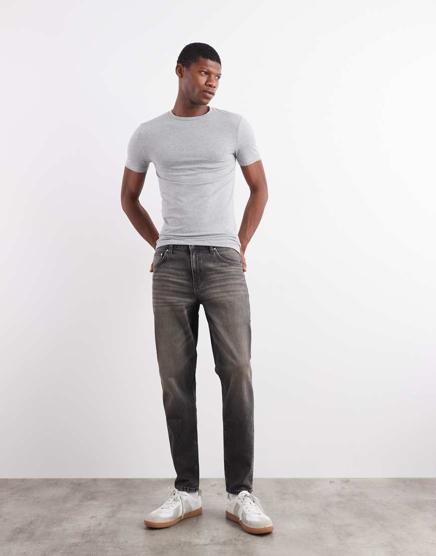 ASOS DESIGN - Schmal zulaufende Jeans in verwaschenem Schwarz mit Gelbstich von ASOS DESIGN