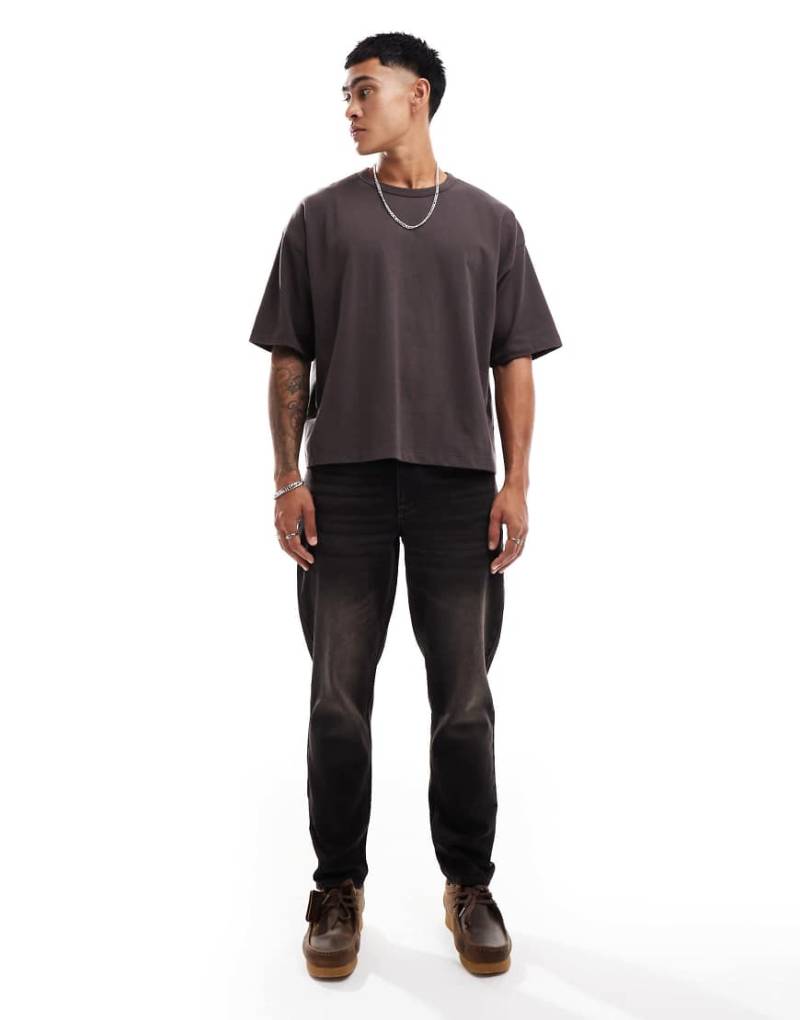 ASOS DESIGN - Schmal zulaufende Jeans in verwaschenem Schwarz mit braunem Farbstich von ASOS DESIGN