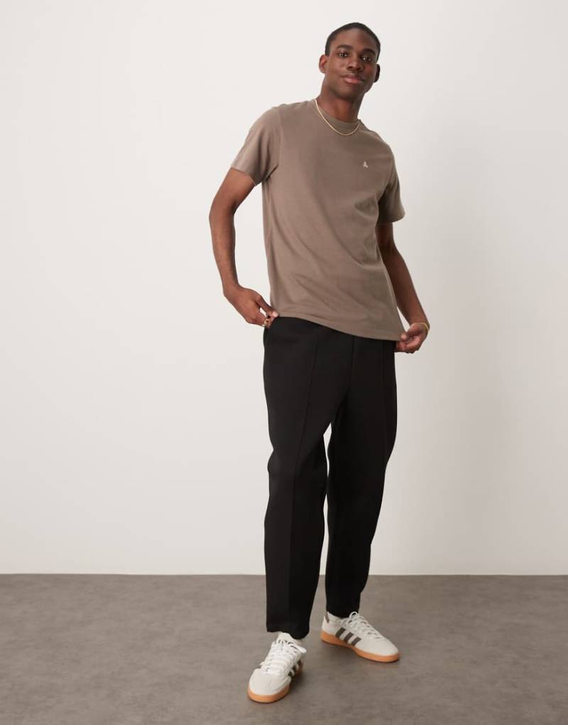 ASOS DESIGN - Schmal zulaufende Jogginghose aus Scuba-Stoff in Schwarz mit Bügelfalte von ASOS DESIGN