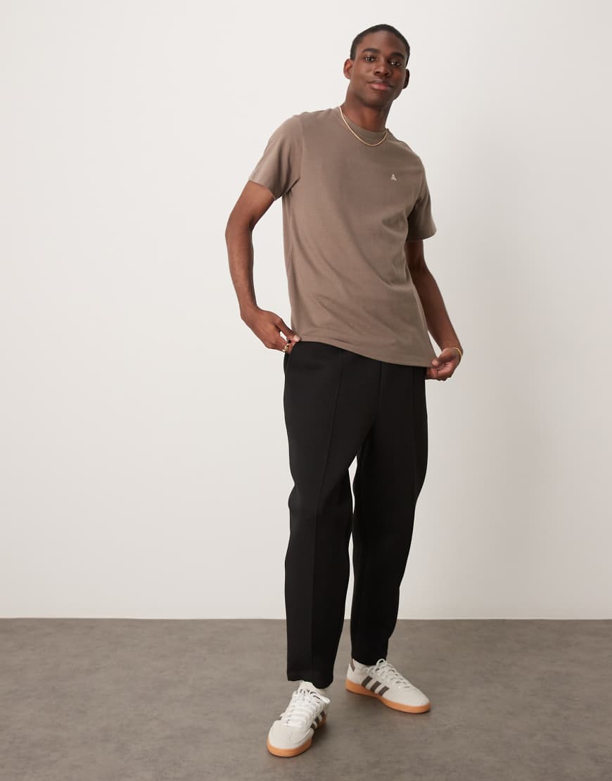 ASOS DESIGN - Schmal zulaufende Jogginghose aus Scuba-Stoff in Schwarz mit Bügelfalte von ASOS DESIGN