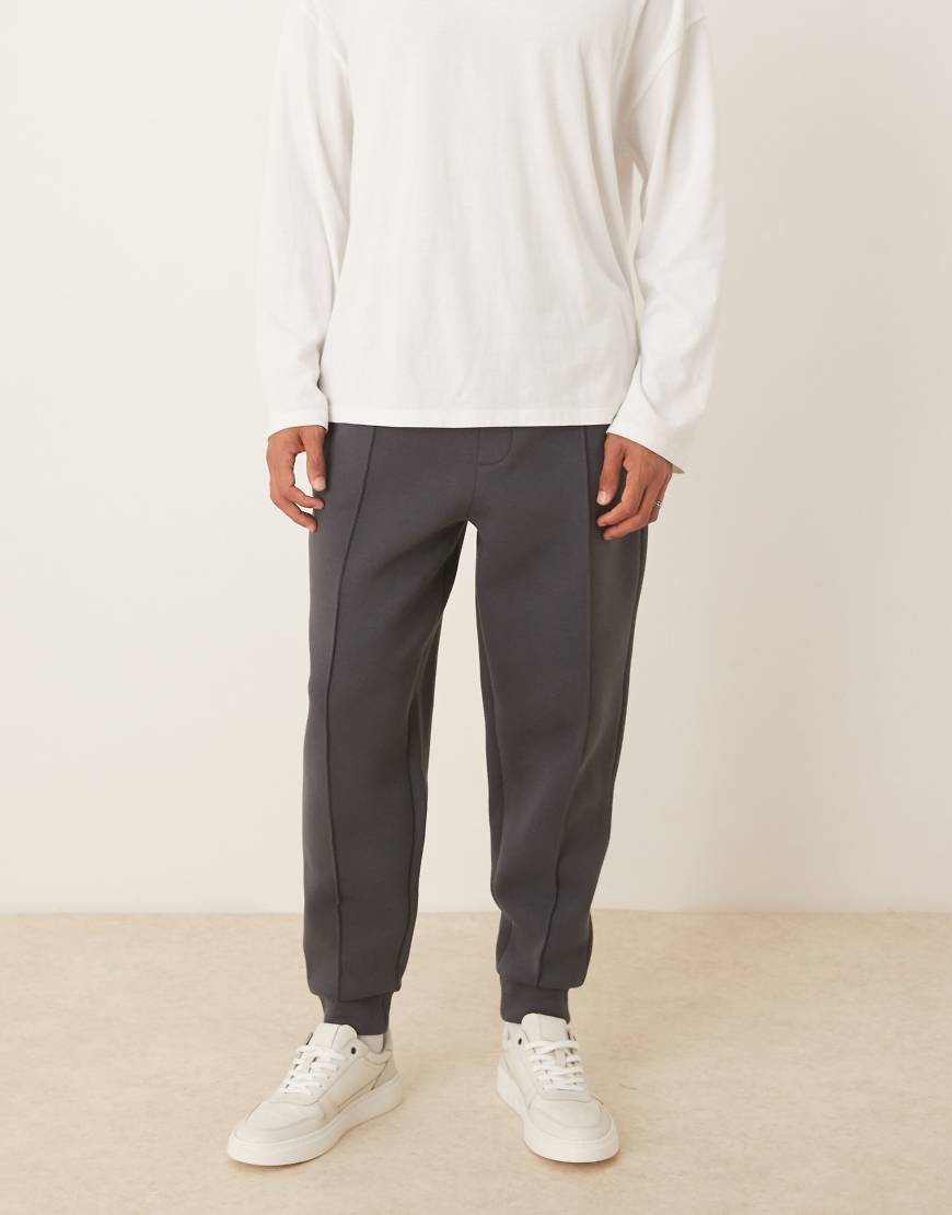 ASOS DESIGN - Schmal zulaufende Jogginghose aus schwerem neoprenartigem Stoff in Anthrazit mit Biesen-Grau von ASOS DESIGN