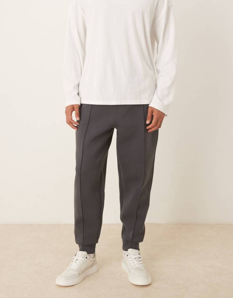 ASOS DESIGN - Schmal zulaufende Jogginghose aus schwerem neoprenartigem Stoff in Anthrazit mit Biesen-Grau von ASOS DESIGN