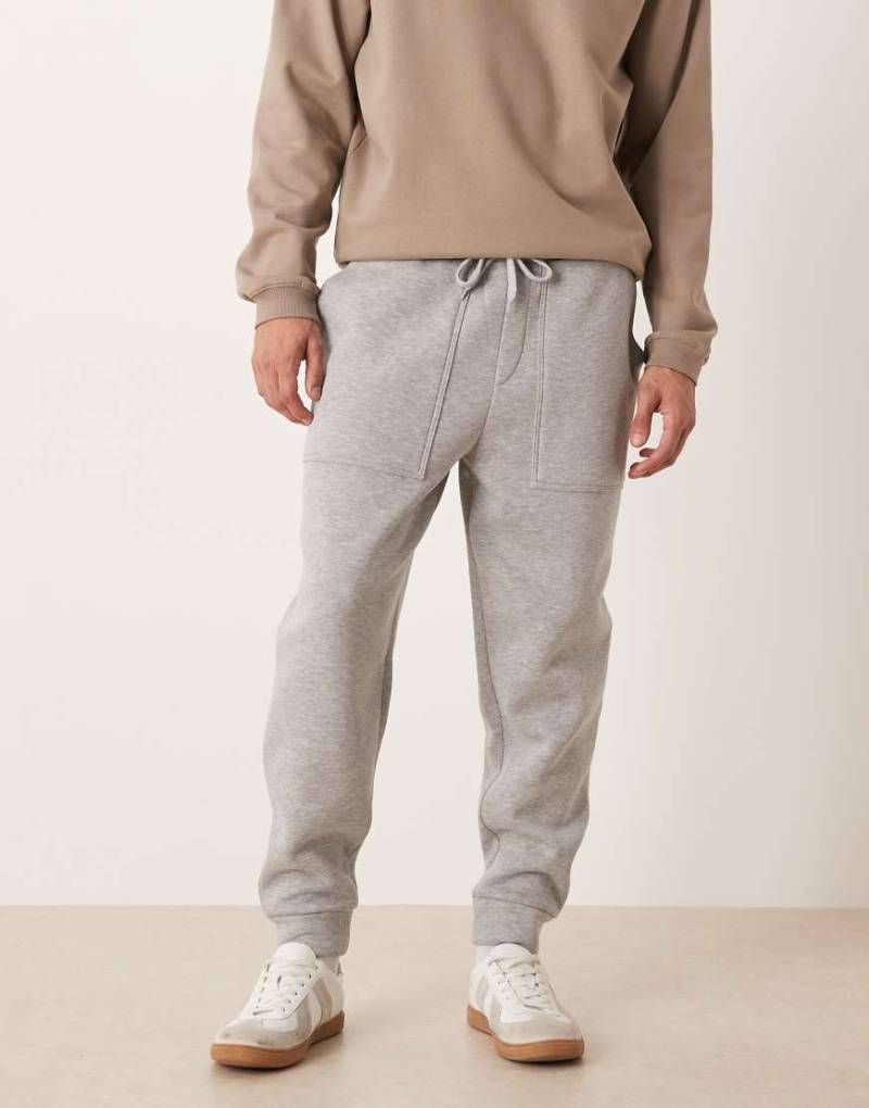 ASOS DESIGN - Schmal zulaufende Jogginghose in Grau meliert mit Taschen von ASOS DESIGN