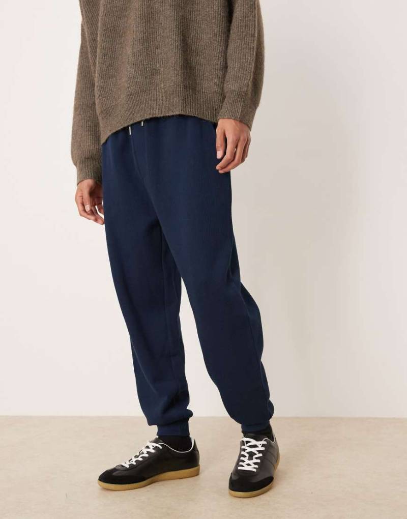 ASOS DESIGN - Schmal zulaufende Jogginghose in Marineblau mit Bündchen von ASOS DESIGN