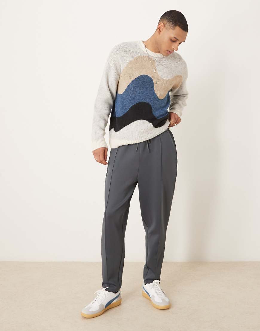ASOS DESIGN - Schmal zulaufende Jogginghose in Neoprenoptik in verwaschenem Schwarz mit Biesen-Grau von ASOS DESIGN