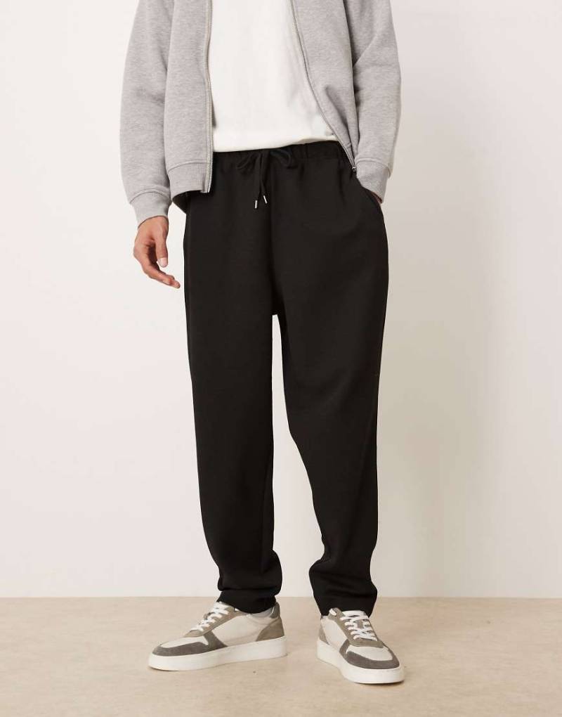 ASOS DESIGN - Schmal zulaufende Jogginghose in Schwarz mit Bundfalten von ASOS DESIGN