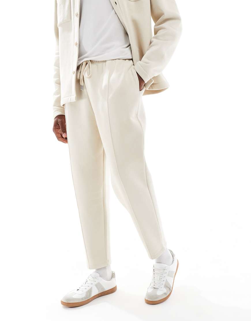 ASOS DESIGN - Schmal zulaufende Jogginghose in Steinbeige mit festem Saum und Falten-Neutral ASOS DESIGN - Schmal zulaufende Jogginghose in Steinbeige mit festem Saum und Falten-Neutral von ASOS DESIGN