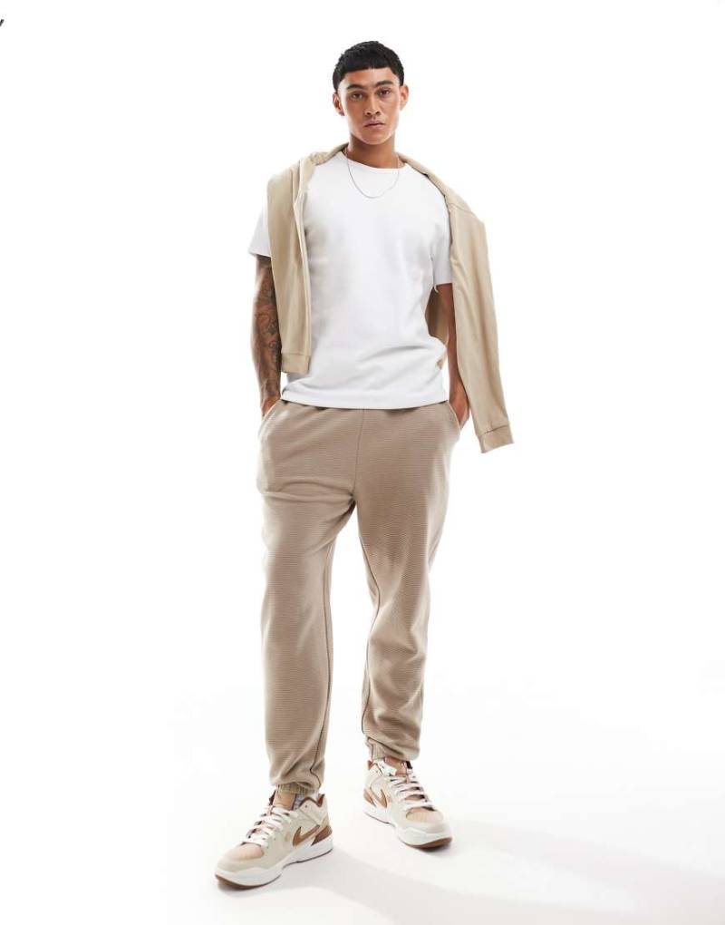 ASOS DESIGN - Schmal zulaufende Jogginghose in geripptem Beige-Schwarz von ASOS DESIGN