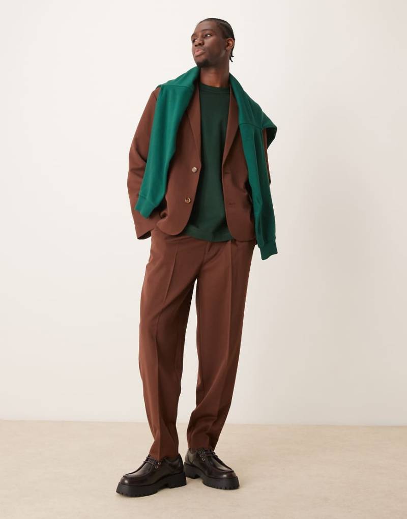 ASOS DESIGN - Schmal zulaufende Oversize-Anzughose aus Twill in Braun von ASOS DESIGN
