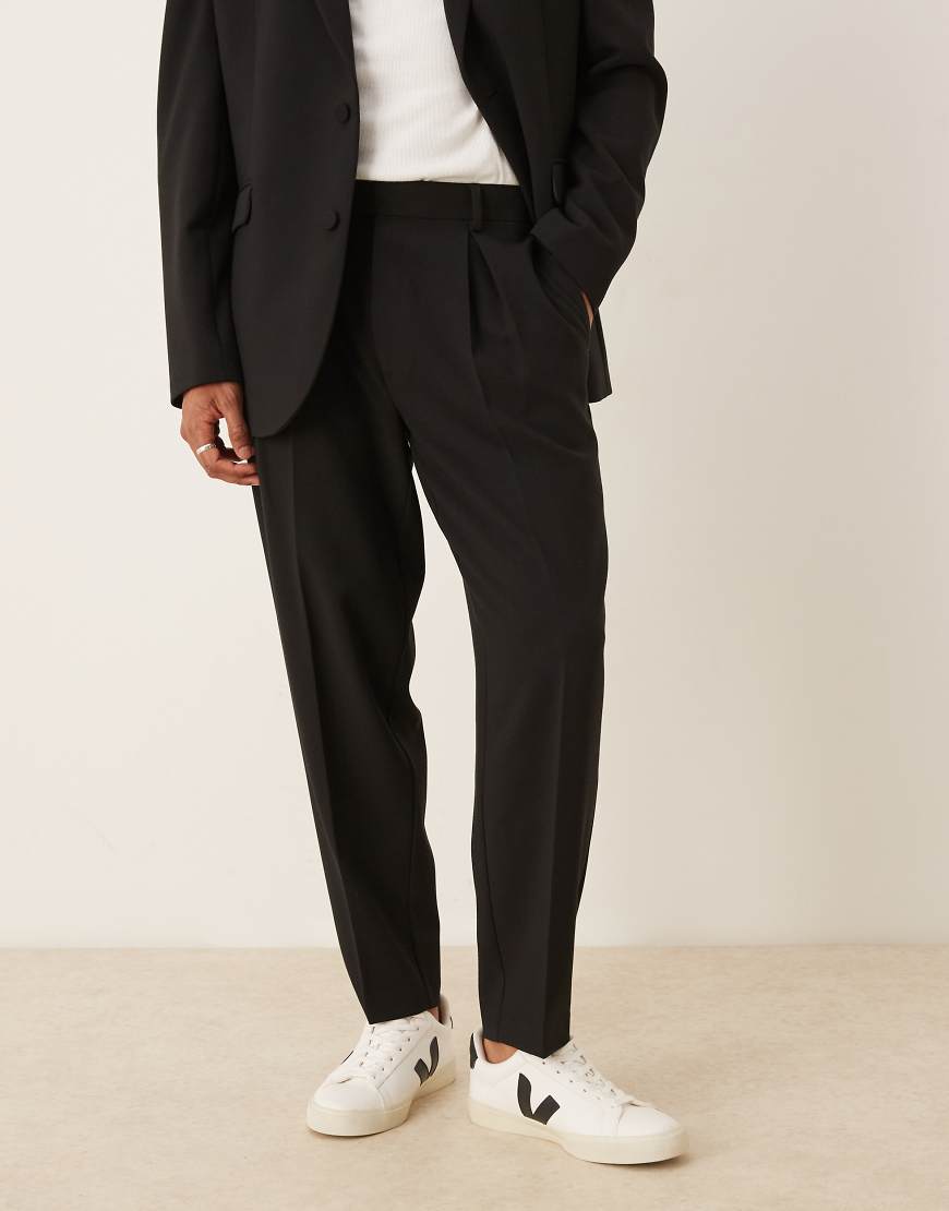 ASOS DESIGN - Schmal zulaufende Oversize-Anzughose in Schwarz ASOS DESIGN - Schmal zulaufende Oversize-Anzughose in Schwarz von ASOS DESIGN