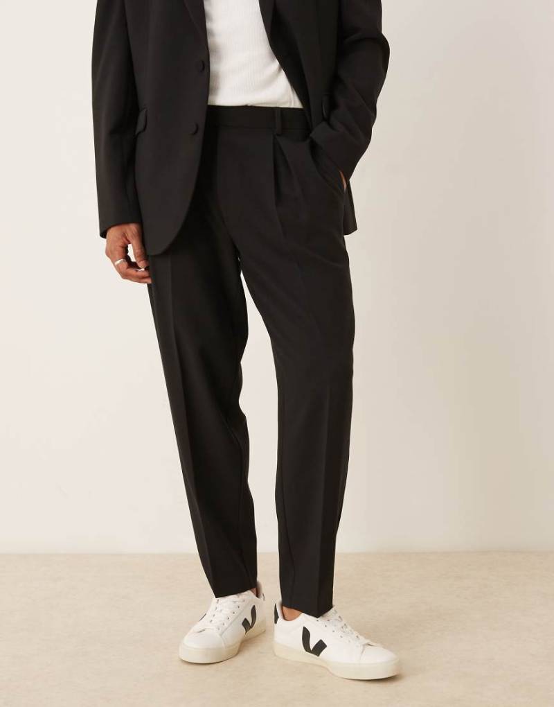 ASOS DESIGN - Schmal zulaufende Oversize-Anzughose in Schwarz von ASOS DESIGN