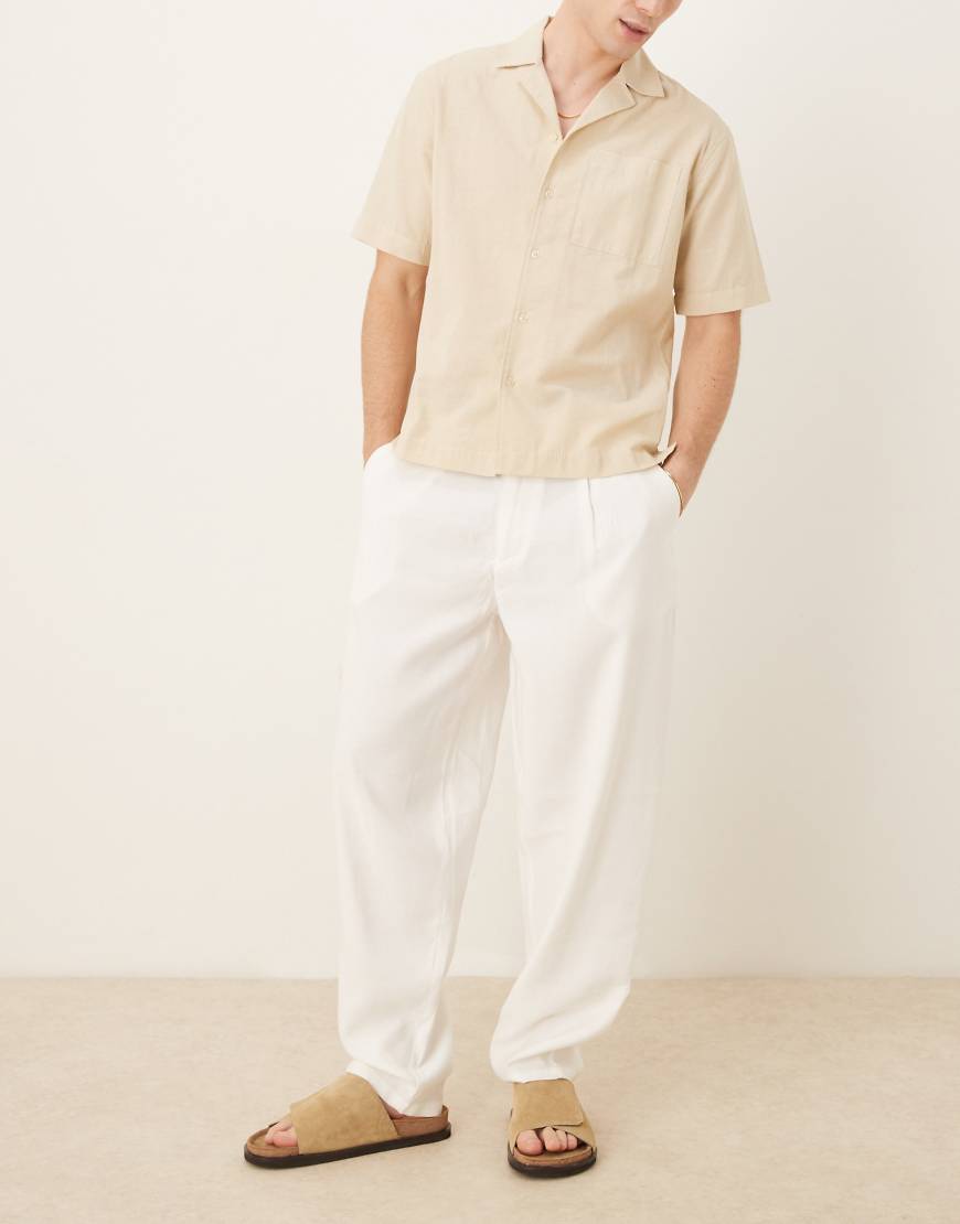 ASOS DESIGN - Schmal zulaufende Oversize-Hose in Weiß mit Detail am Bund von ASOS DESIGN