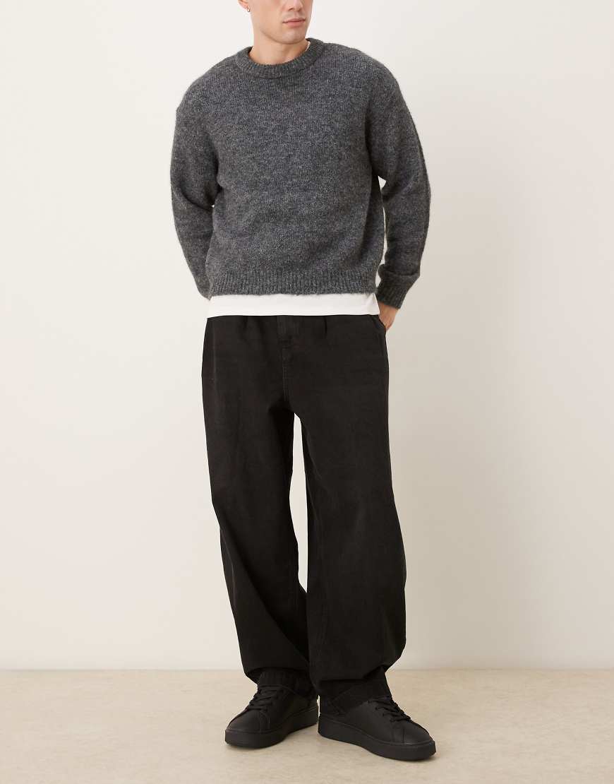 ASOS DESIGN - Schmal zulaufende Oversize-Jeans in Schwarz mit Falten von ASOS DESIGN