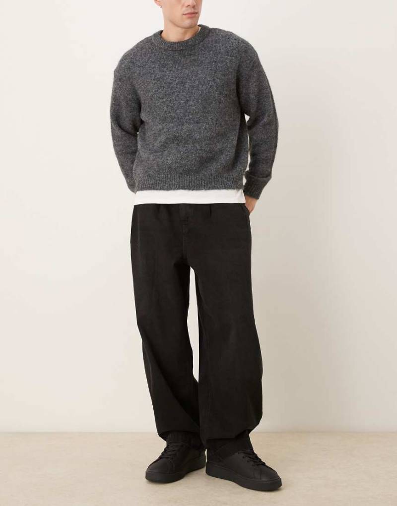ASOS DESIGN - Schmal zulaufende Oversize-Jeans in Schwarz mit Falten von ASOS DESIGN